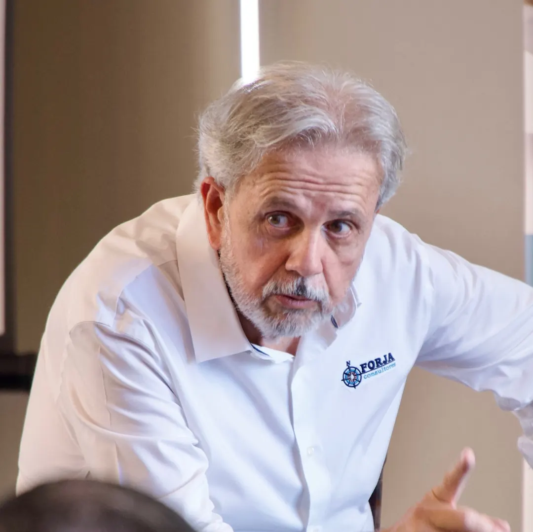Eduardo Martí sentado, señalando con la mano mientras conversa con los participantes de una mentoría